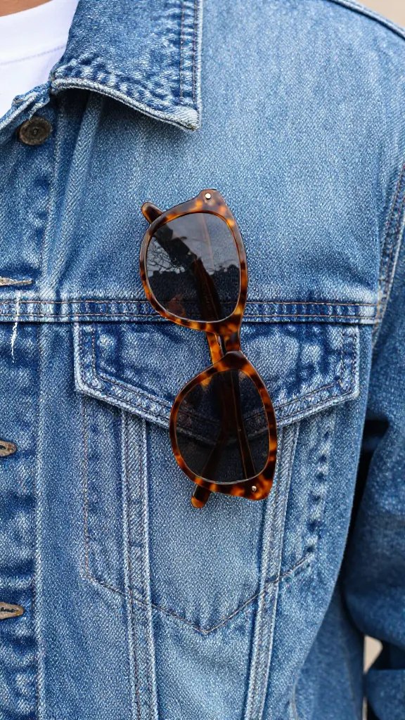 tortoiseshell sunglasses on denim jacket chest pocket