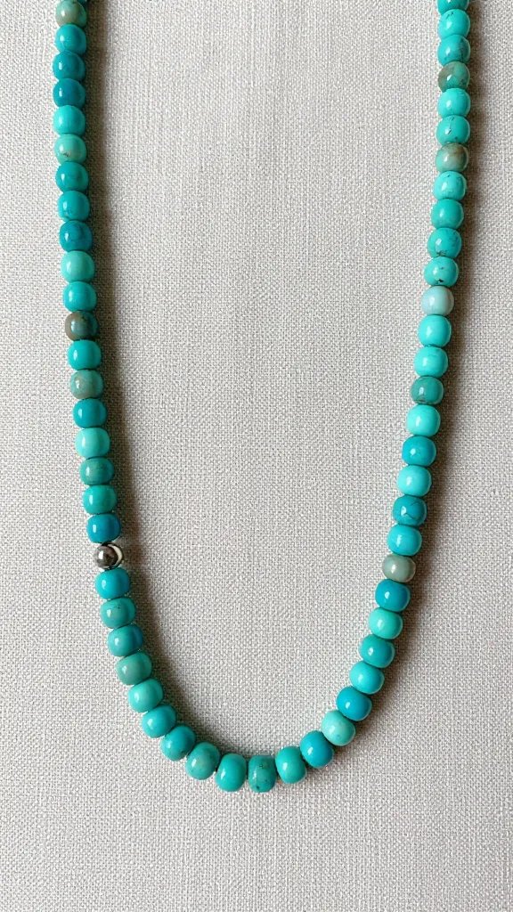 heishi turquoise strand necklace detail against linen backdrop