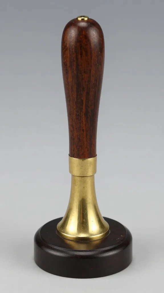 brass heel spur rowel, engraved, on dark wood